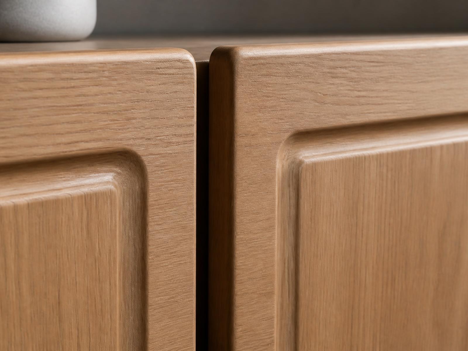 Close-up of oak wood-grain thermofoil cabinet doors with curved profile edges